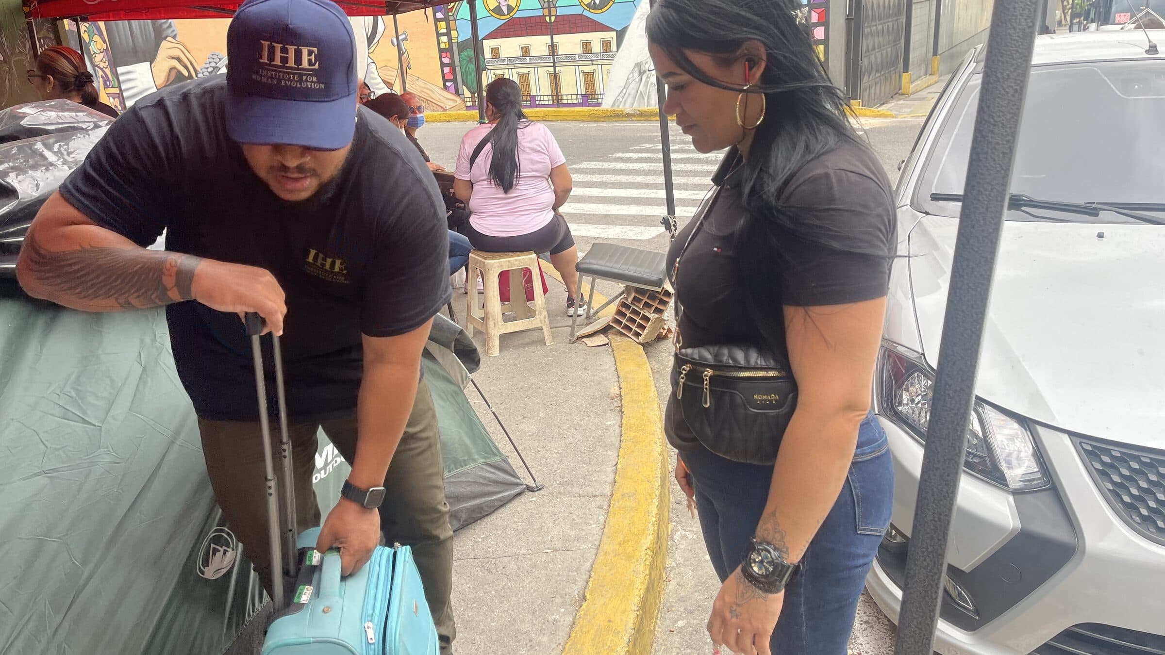 Un miembro del equipo de IHE llega al campamento tirando de una maleta cargada de suministros.