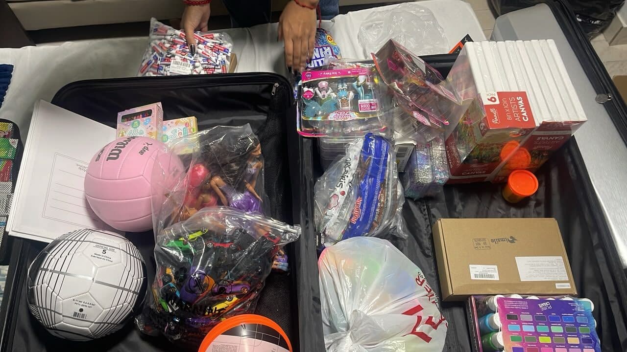 Voluntarios empacan maletas con juguetes, balones y material de arte para los niños afectados por el terremoto en Venezuela.