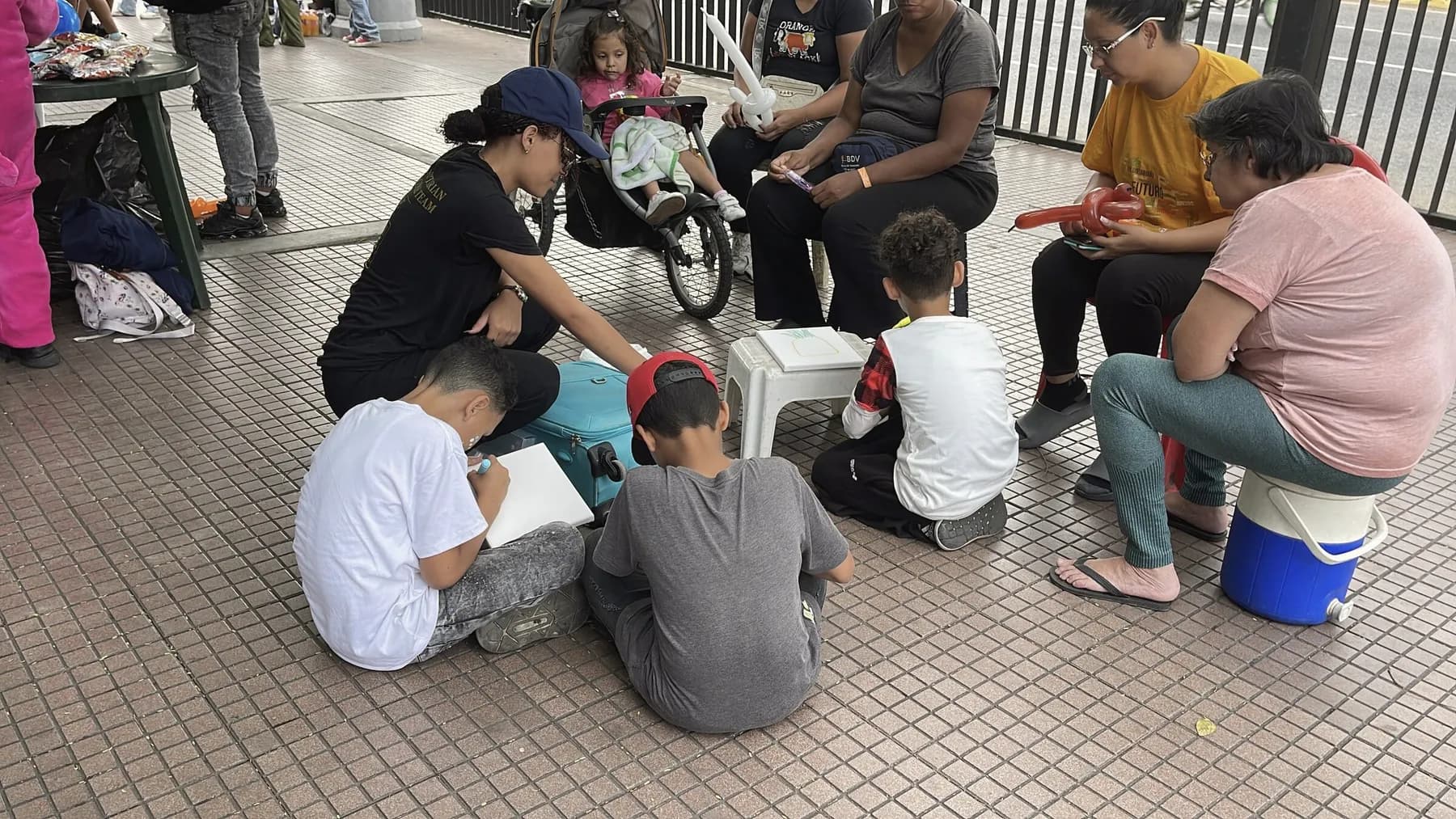 The IHE team sitting in a circle with children during the art workshop