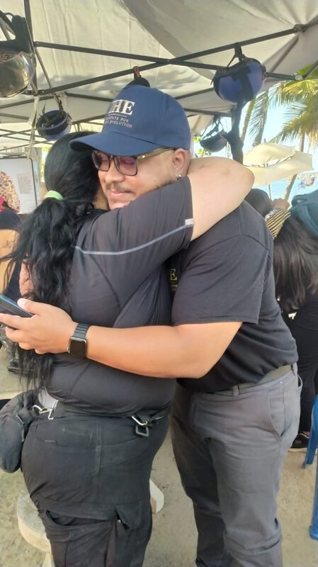 A grateful community member embracing Juan, who wears an IHE cap, during the mission.