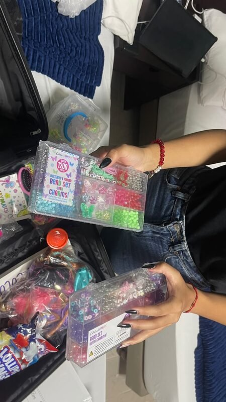 Hands sorting small toys and supplies into a bag.