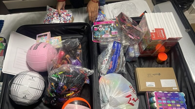 A storage bin filled with toys, games, and packaged supplies.